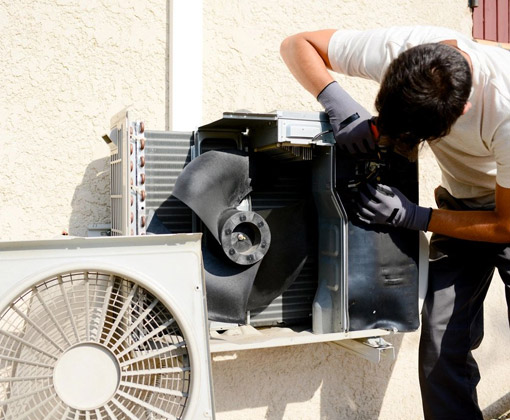 A man is fixing the air conditioner outside.